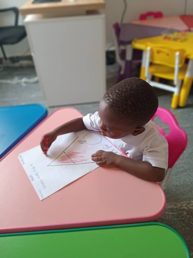 Kindergarten learner practising drawing and early writing