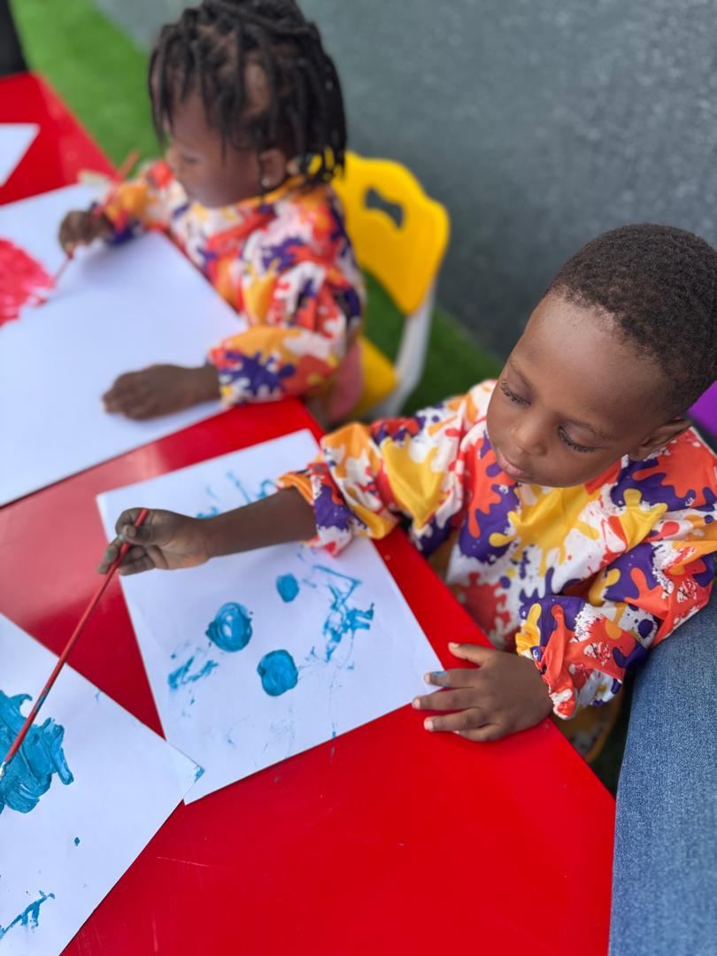 Nursery child doing a painting activity